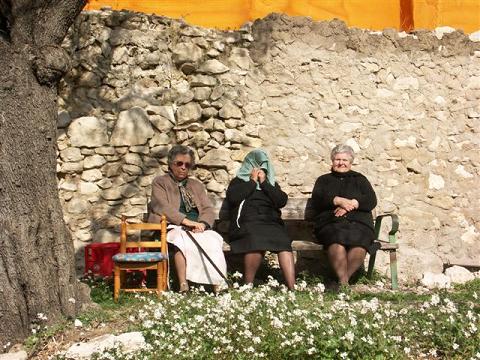 Drie Spaanse dames op een zonnig bankje.