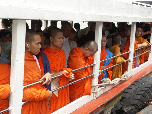 Ook monniken hebben soms een iPod, zelfs al staan ze op de speciaal voor hen gereserveerde plaatsen op de boot.